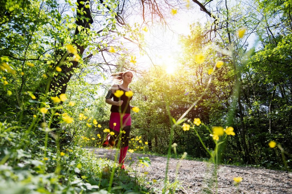 woman running along a wooded trail