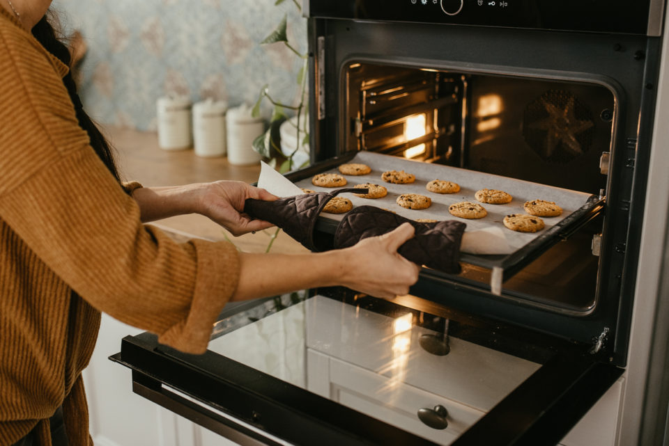 Putting tray of cookies into oven