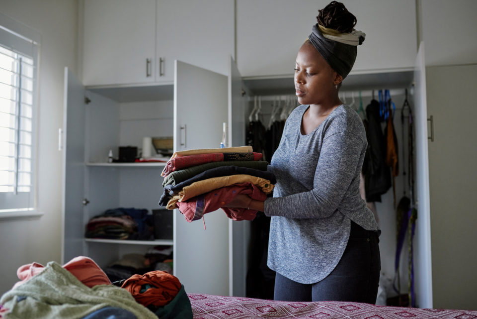 Cropped shot of a young woman folding her laundry at home