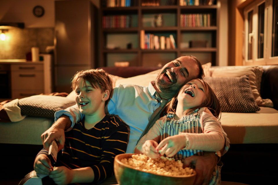 Close up of a father watching television with his kids