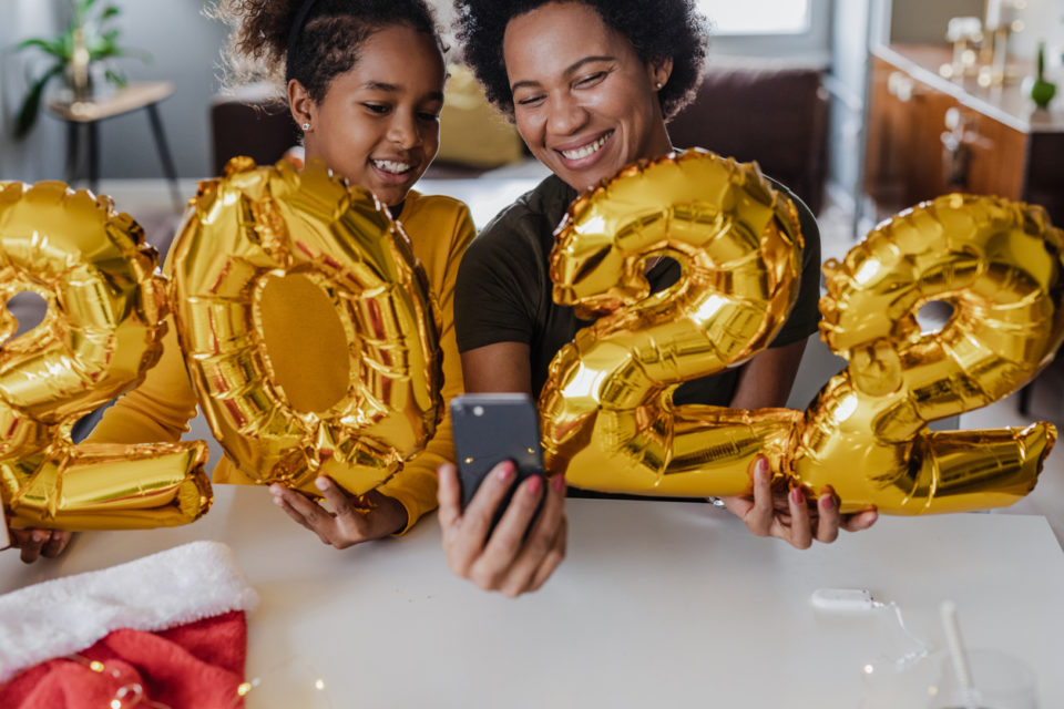 Mother and daughter holding balloons for New Year 2022