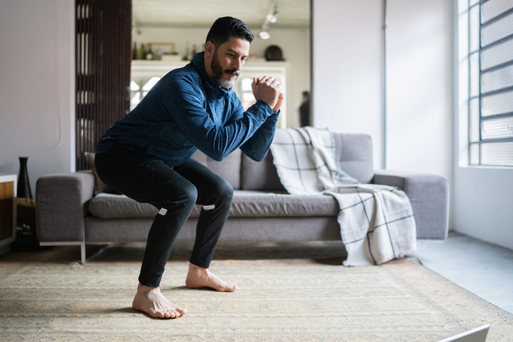 Mature man squatting at home